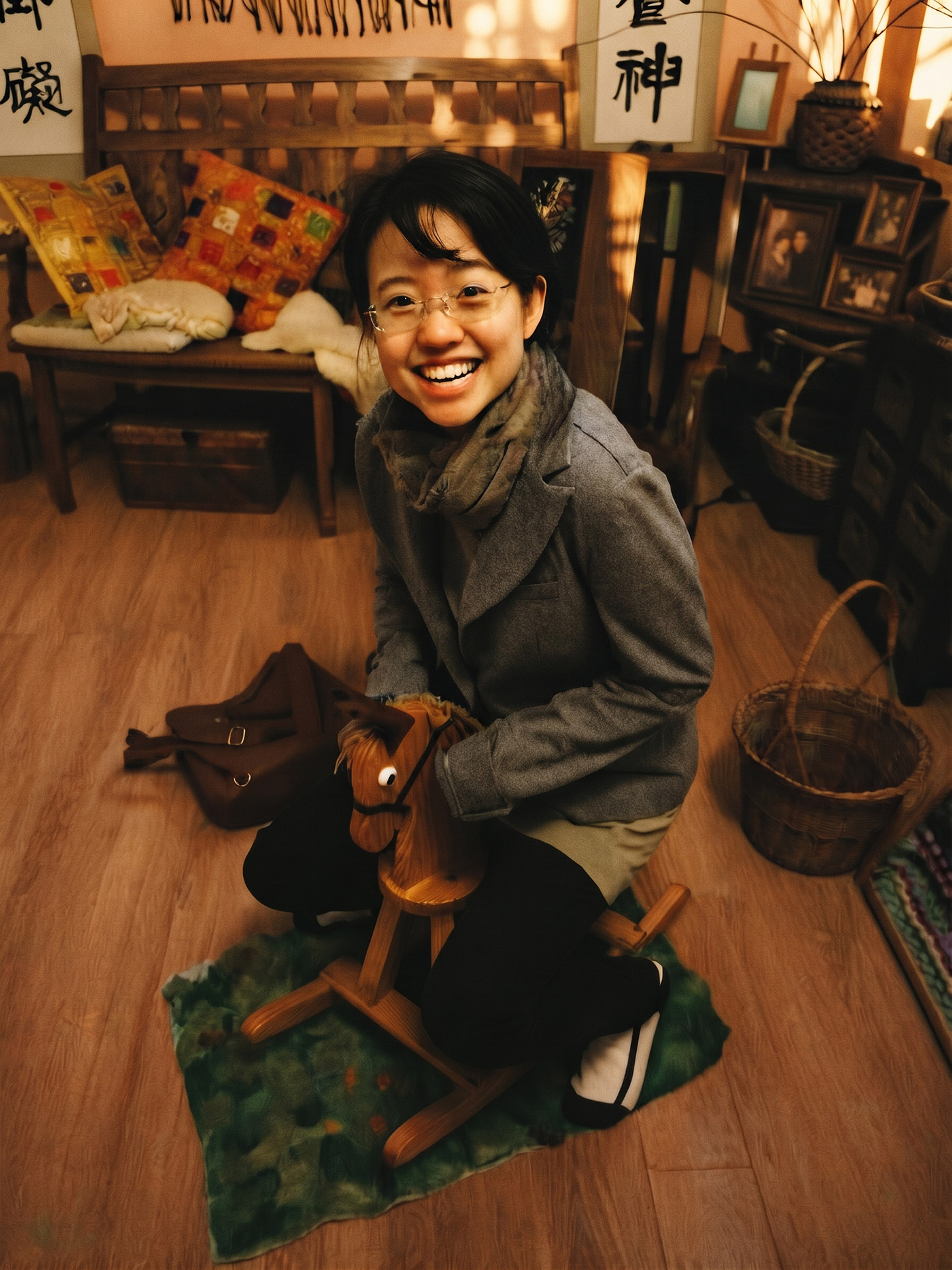 Lilian Fu smiling, sitting on a wooden rocking horse